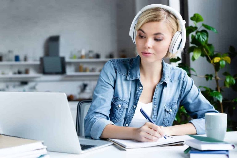 Woman studying with headphones and laptop
