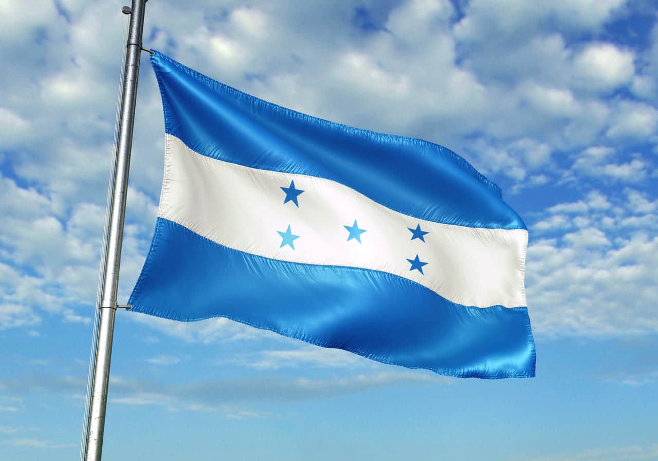 Honduran flag waving under a bright sky