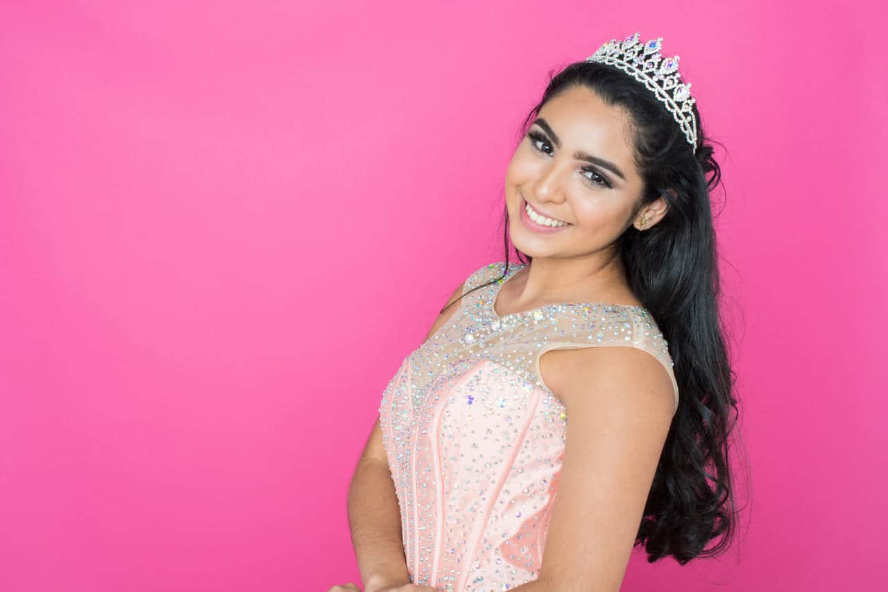 Smiling girl in tiara against pink background