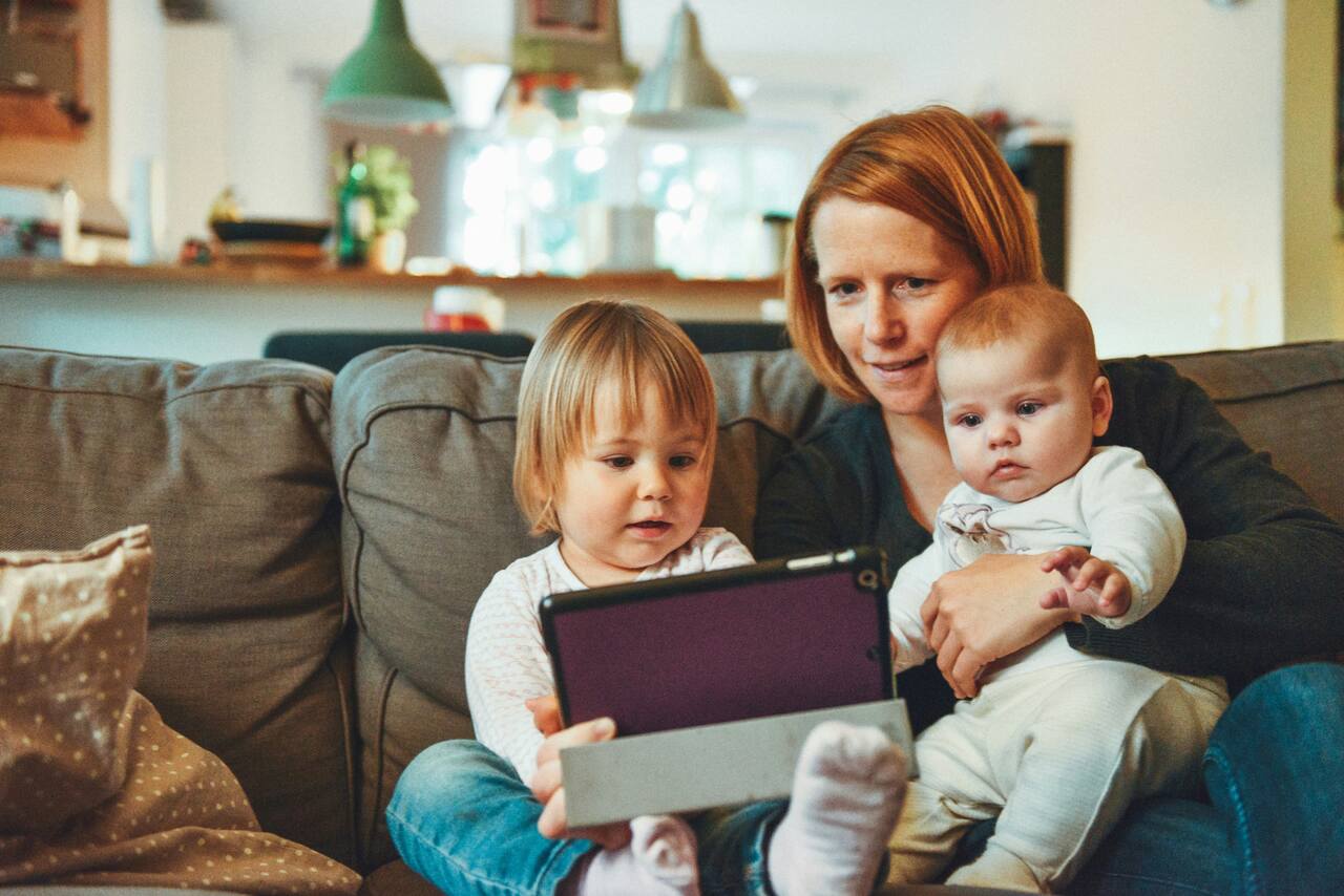 Mother with two children watching a tablet