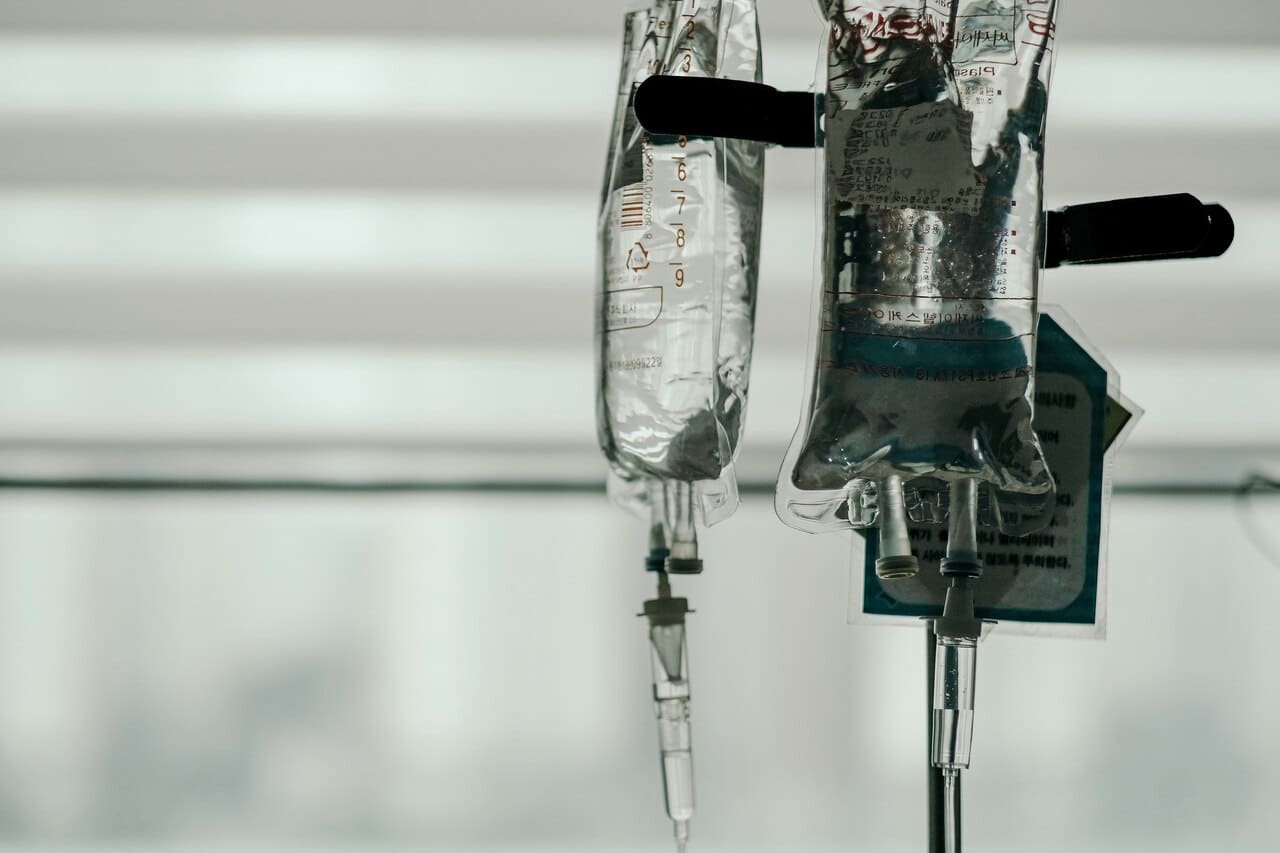 Two IV bags hanging in a hospital room
