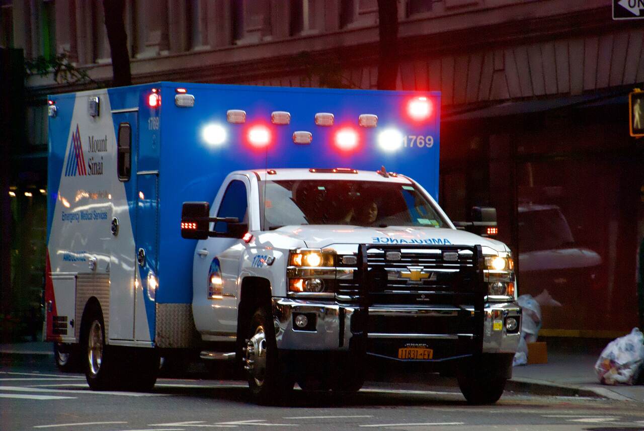 Mount Sinai ambulance with lights on in the city.